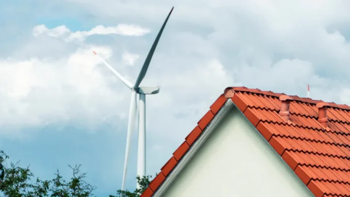 energia-eolica Pequena turbina eólica residencial instalada no quintal de uma casa, girando com o vento enquanto gera energia limpa