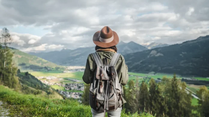 viagens-sustentaveis-4 Viajante contemplando paisagem natural usando práticas sustentáveis - Viagesn Sustentáveis